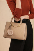Bolso elegante con pompon y detalles dorada,