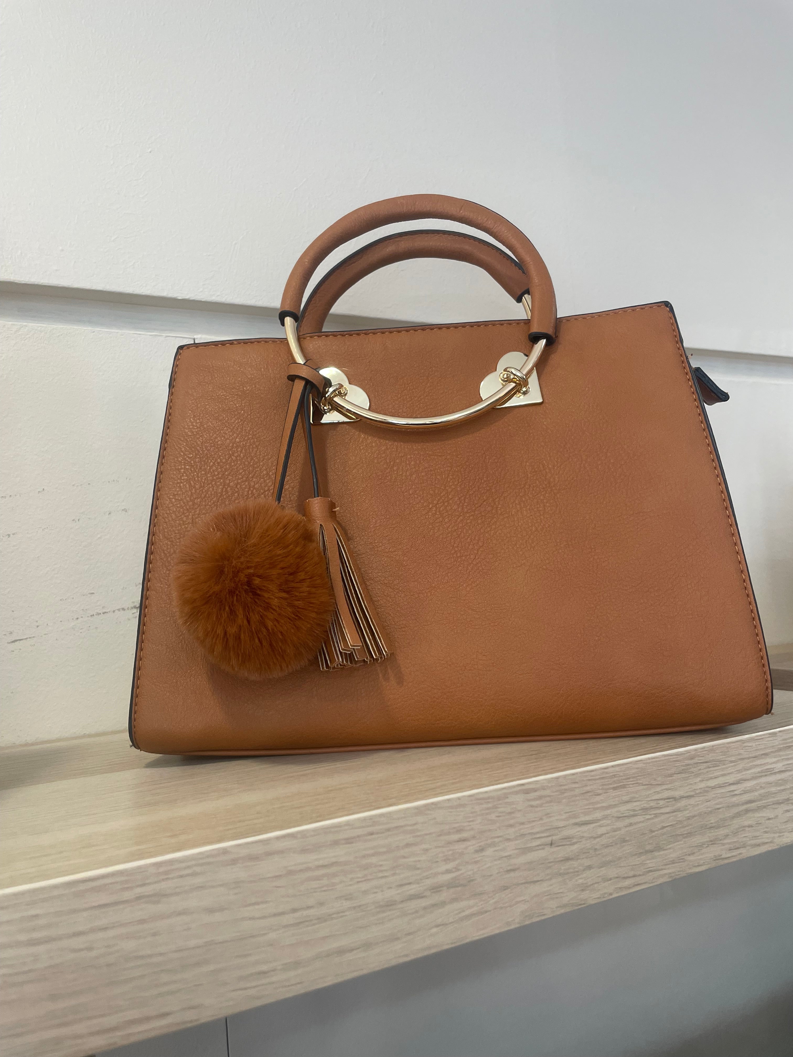 Bolso elegante con pompon y detalles dorada,