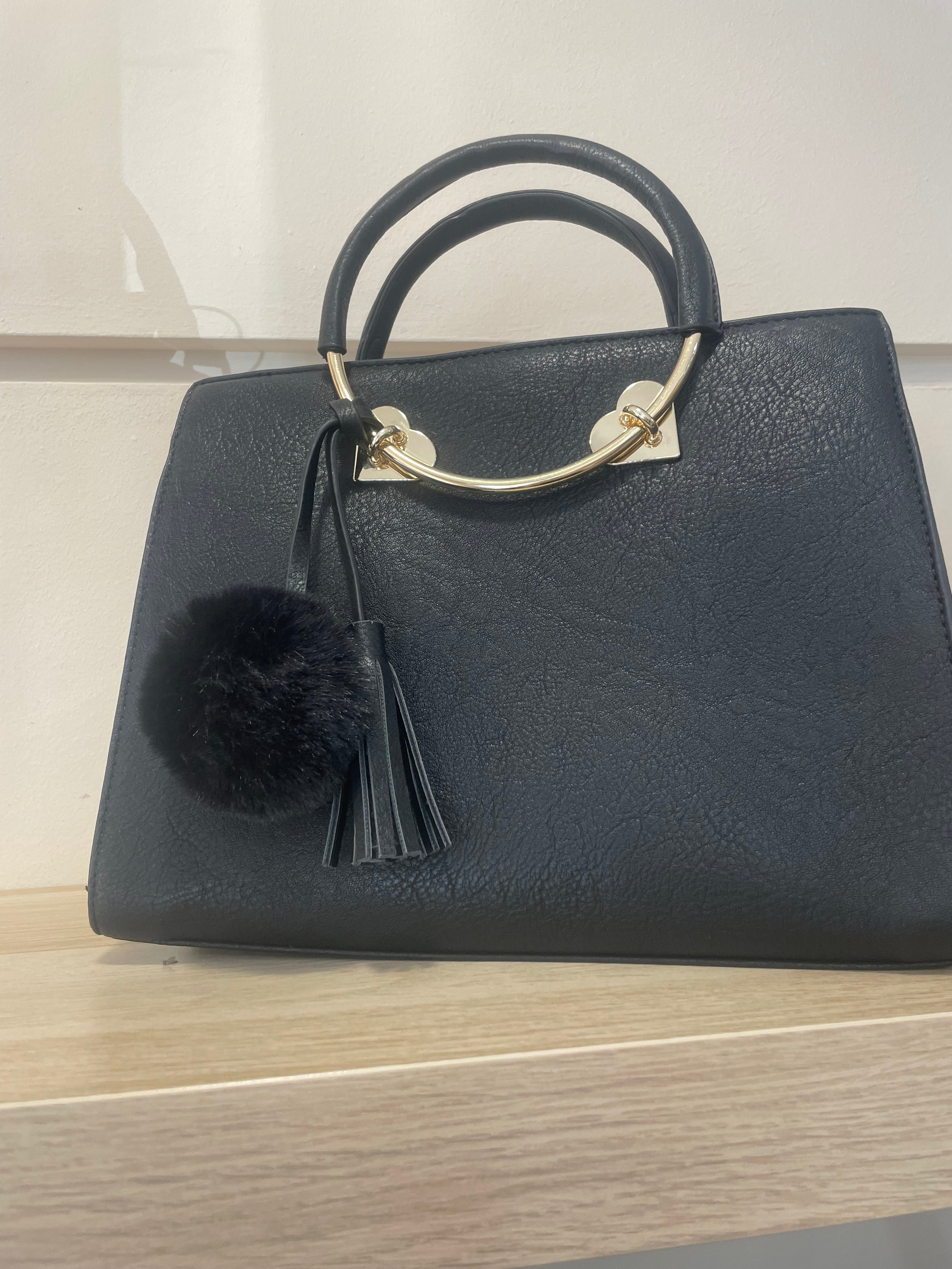 Bolso elegante con pompon y detalles dorada,